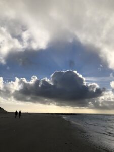 wolk met zon en 2 mensen in de verte